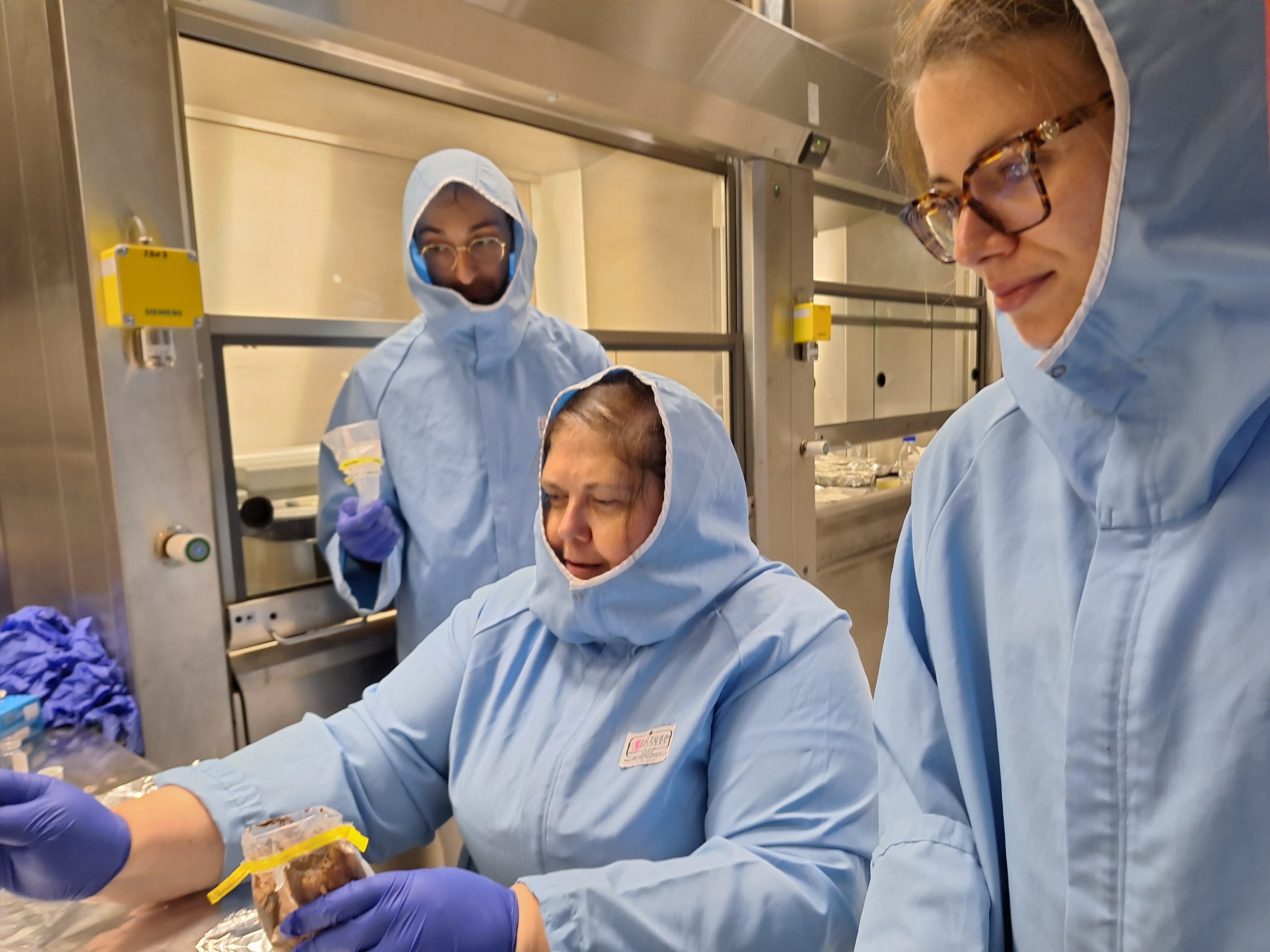 Three ICEBERG researchers in a laboratory analysing samples.