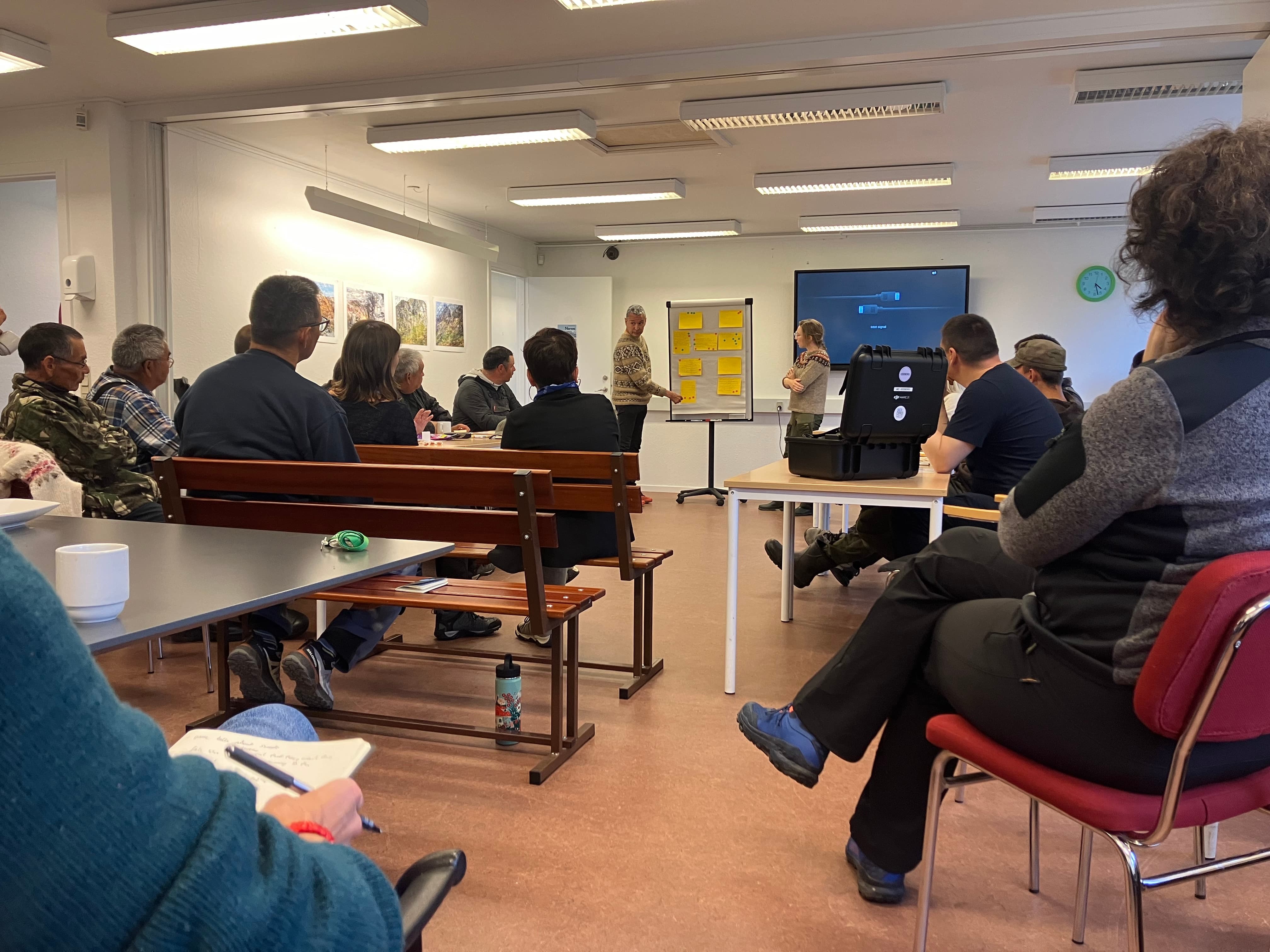 People having a meeting in a small conference room.