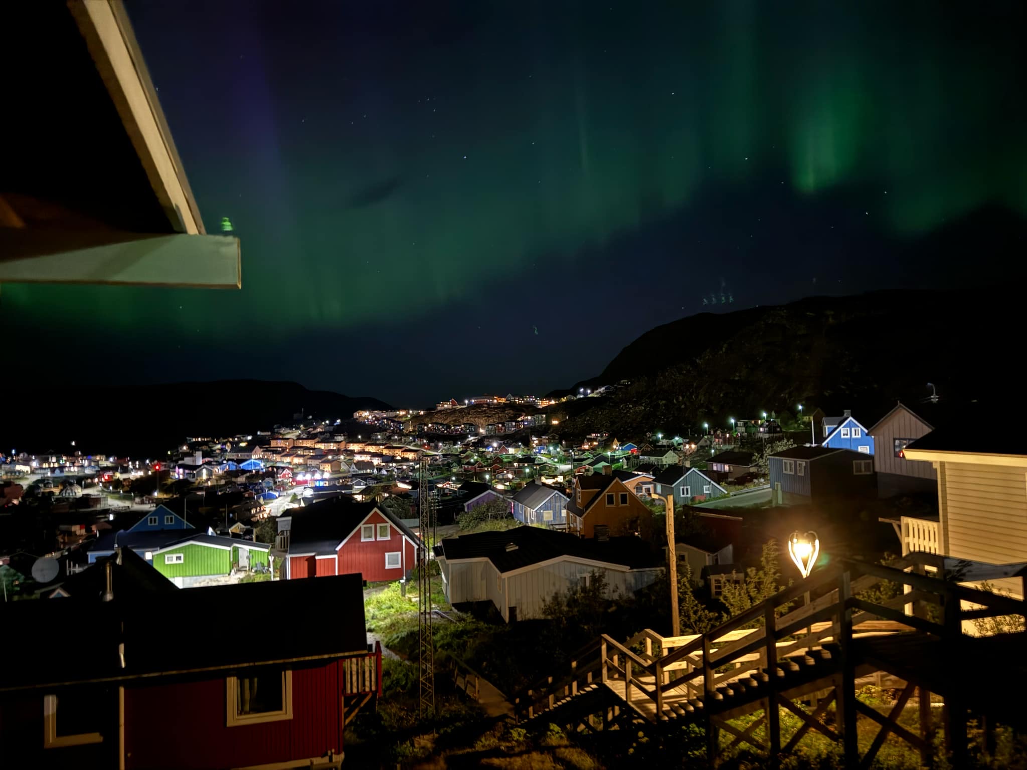 Northern lights above a village in night.