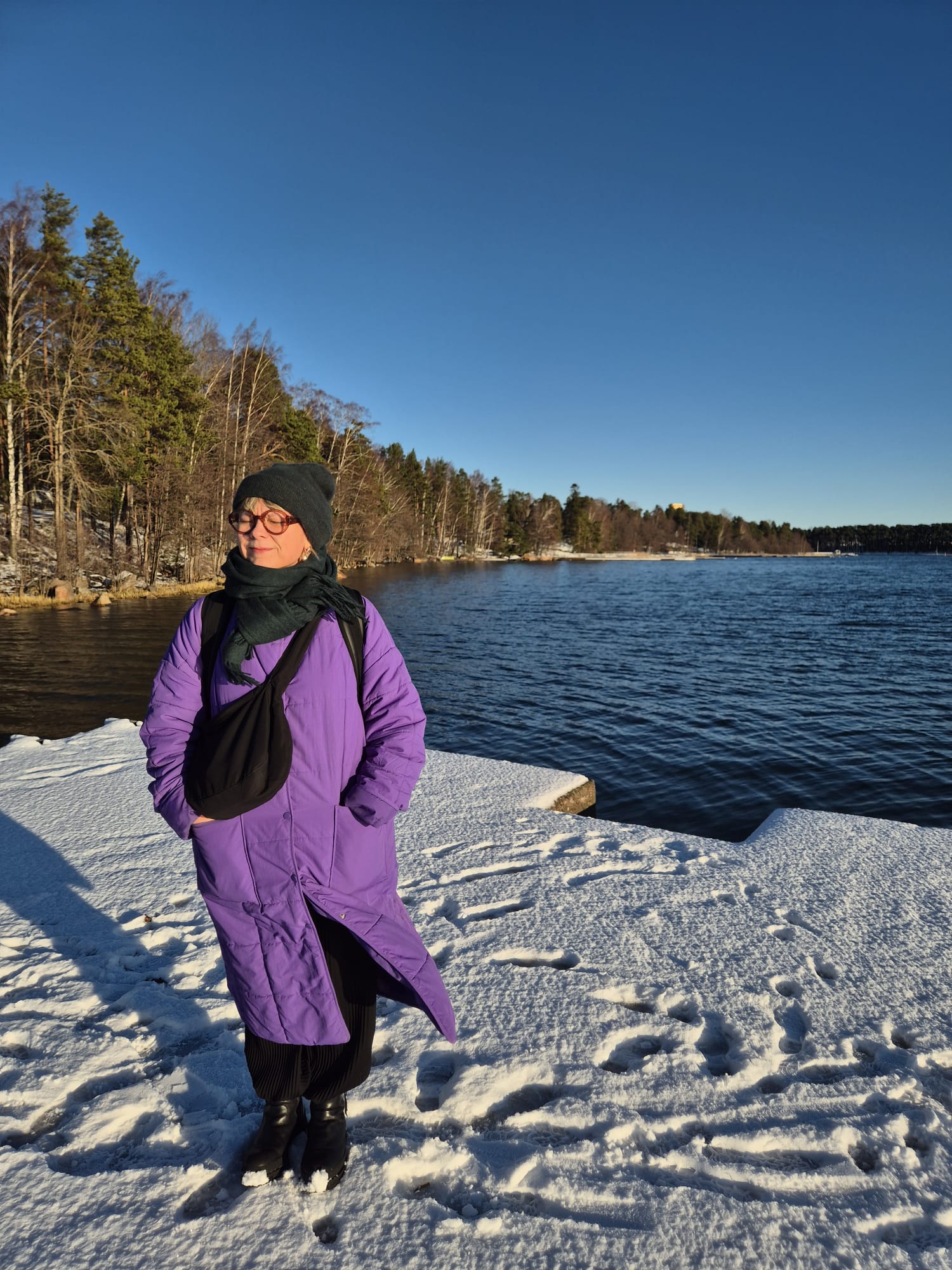 Marika Ahonen standing on snow near a lake.