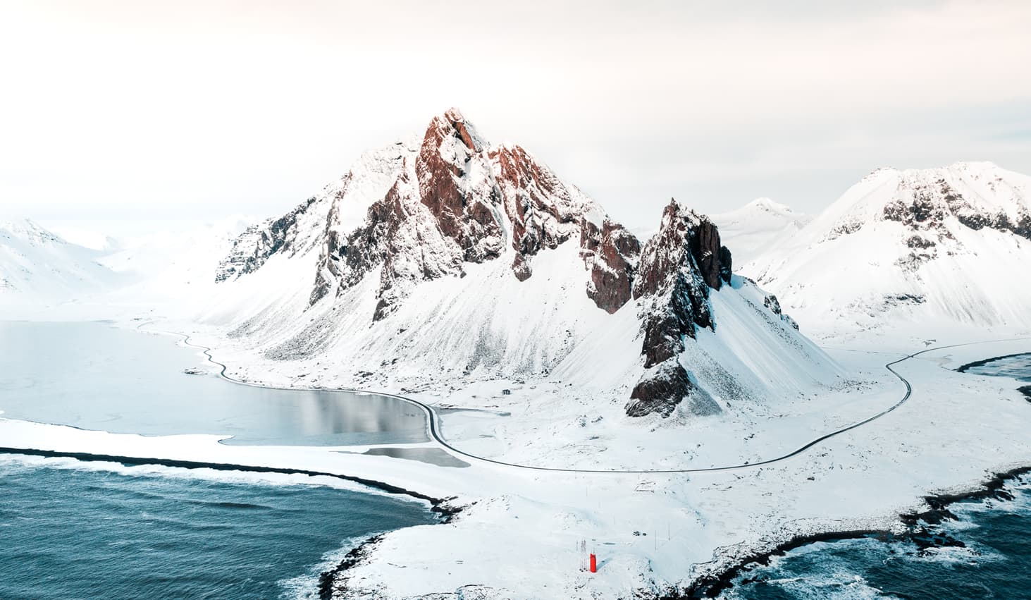 A landscape with sea, ice and snowy mountains.