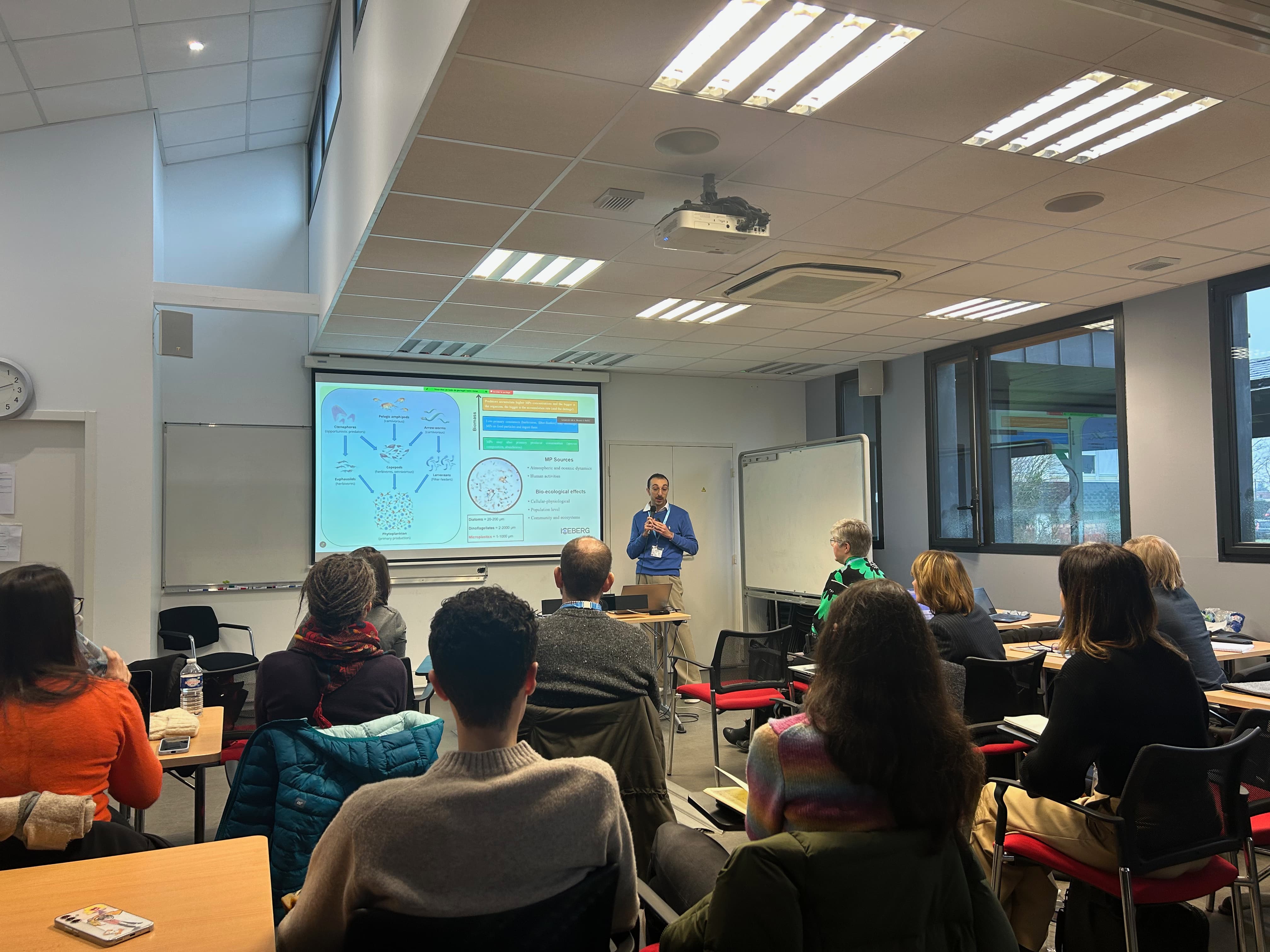 In a small conference room, ICEBERG's Early Career Researcher Alessandro Nicolai gives a presentation and other ICEBERG people are listening.