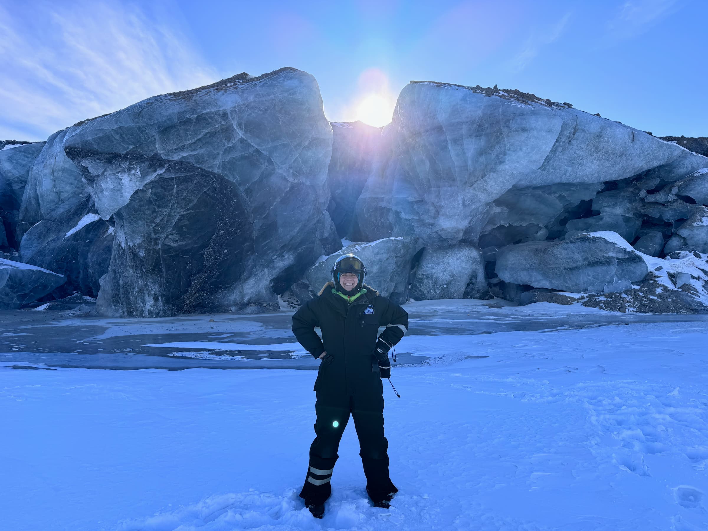 In a snowy landscape Beatrice Ulgelmo in full winter clothing and helmet standing on a glacier in front of a valley between two large rocks.
