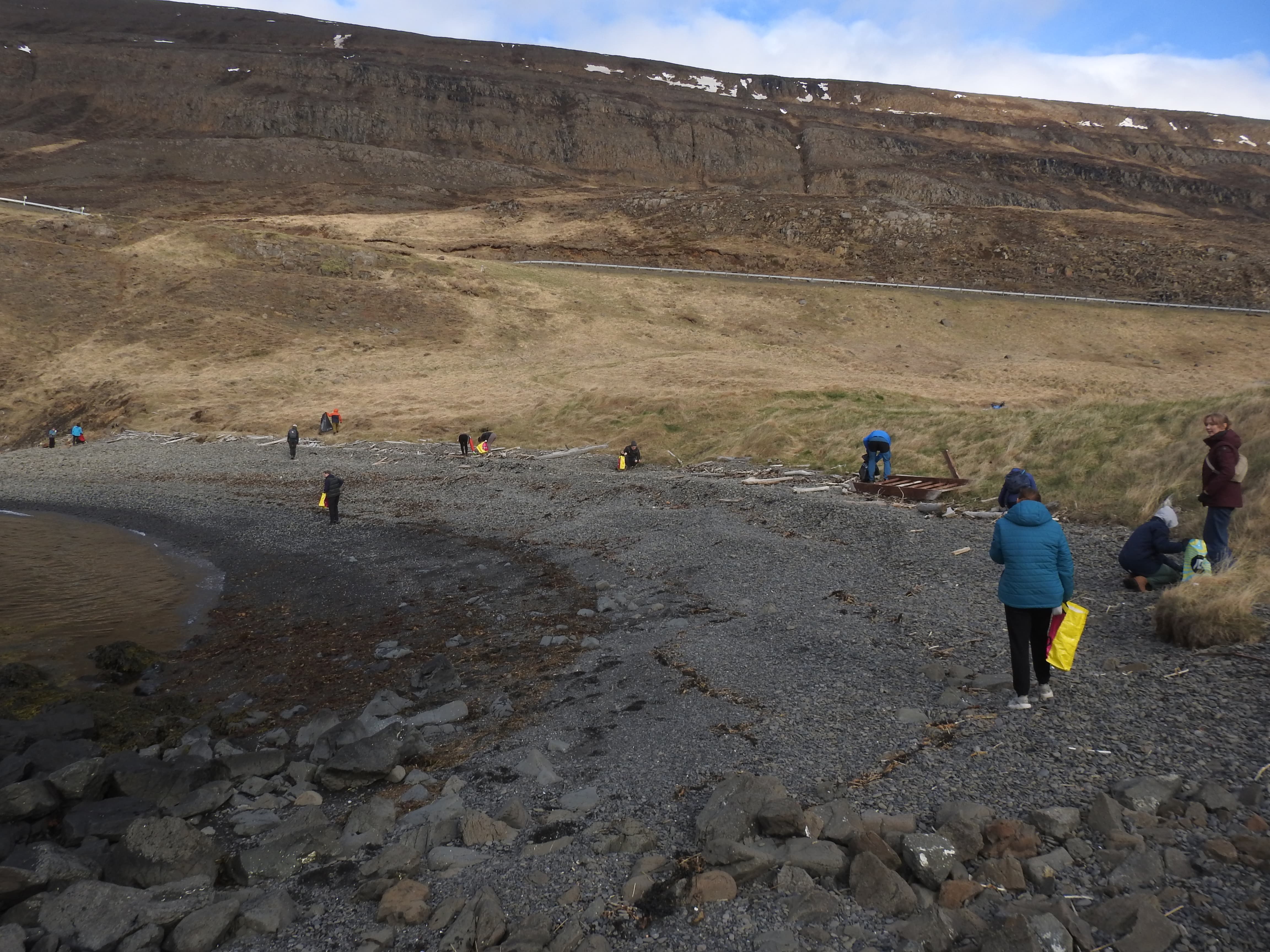 Volunteers walking a rocky road with a rocky hill ahead.