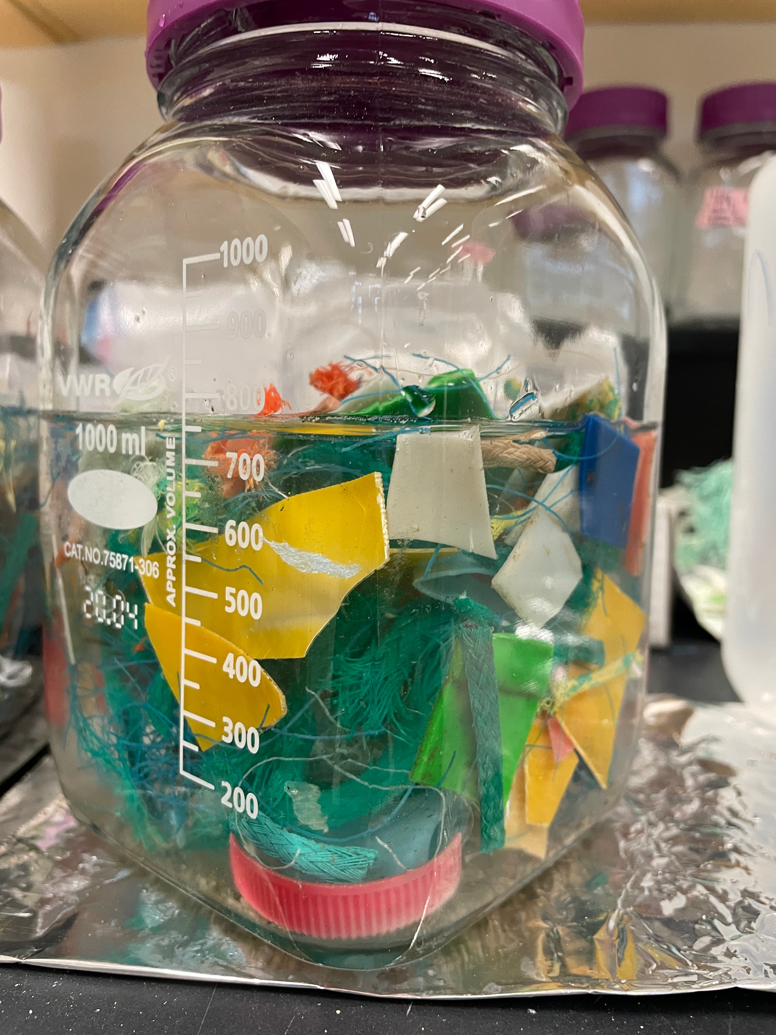 A glass jar that has colourful plastic pieces inside.