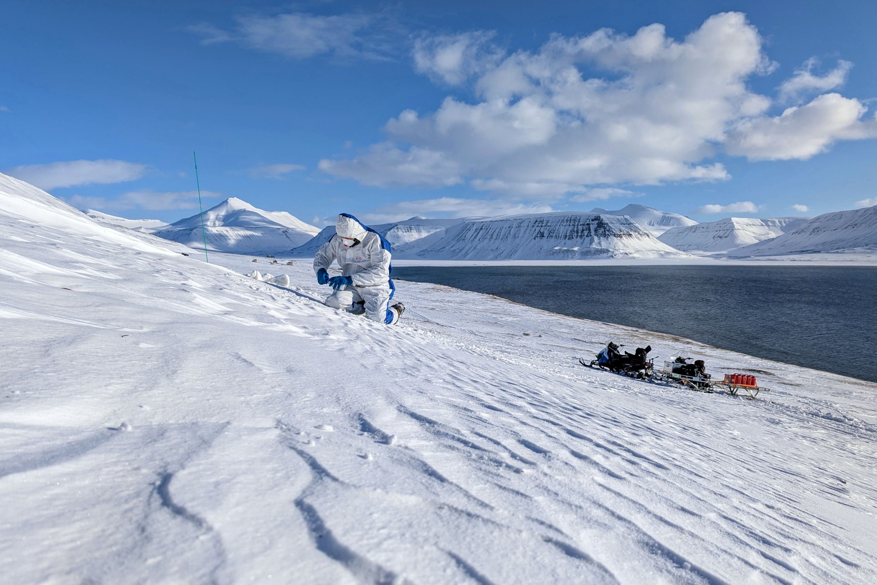 A person taking samples in a snowy landscape.