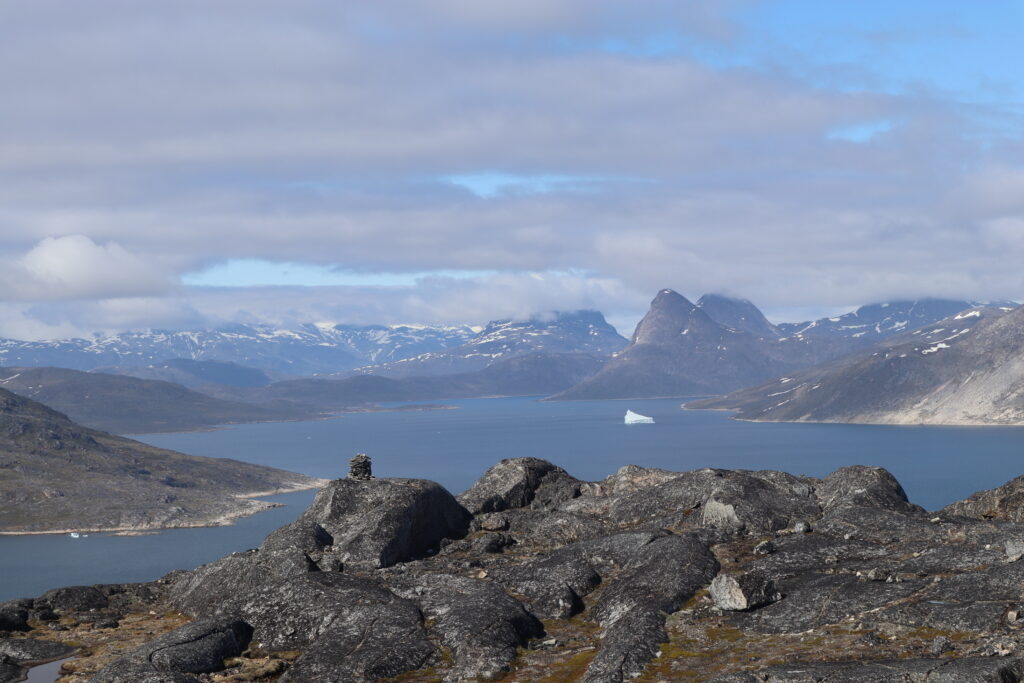 A mountain landscape, a small piece of ice can be seen in the water far away.